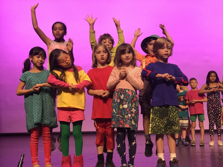 Stage performance ES kids in colorful costumes