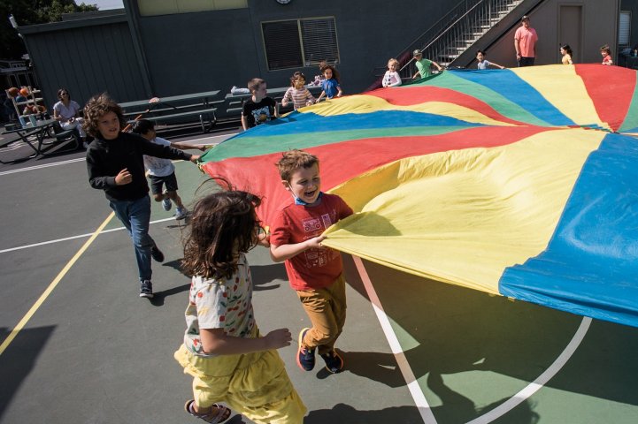 ES PE students running rainbow tent